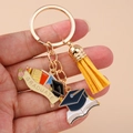 Detail view of Graduation keychain with golden ring tassel and enamel graduate charms - Round Ring - Doctoral Hat Certificate