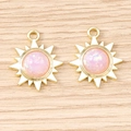 Gros plan de pendentifs soleil dorés avec résine rose scintillante pour bijoux DIY - Violet Or