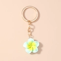 Detalle del llavero de flor de plumeria de resina verde menta con aro dorado sobre rosa - Verde