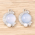 Detailed close-up of blue moon star charms with opal-like stone and white pearls - Silver Base - Light Blue