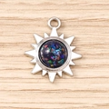 Gros plan d'un pendentif soleil argenté avec résine colorée sur fond en bois clair - Noir Argenté