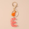 Detail von Buchstaben E Harz Schlüsselanhänger mit Pailletten und orange Quaste - Glitzer Buchstabe E