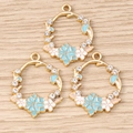 Floral wreath charms with enamel petals and crystal accents on a light wooden surface - 10 Pieces Pack / Blue