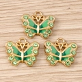 Vista detallada de colgantes de mariposa dorados con esmalte verde y brillantes pedrería - Paquete de 10 / Verde