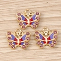 Detailaufnahme goldener Schmetterlingsanhänger mit lila Emaille und rosa Strasssteinen - 10er Pack / Lila