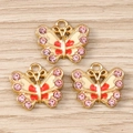 Detalle de dijes de mariposa con esmalte blanco, puntos rojos y cristales rosas - Paquete de 10 / Rosa
