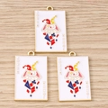 Gros plan de trois breloques Joker émaillées pour bijoux DIY sur fond de bois clair - Lot de 10 / Carte Joker