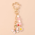 Detail van bloemen sleutelhanger met kersenbloesemhaak, vlinder en parel kralenketting - Roze Bloem Vlinder