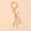 Detalle de llavero de mariposa con perlas coloridas y colgante floral de esmalte brillante - Flor Blanca Perla Mariposa Gato