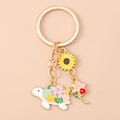 Détail des breloques de porte-clés tournesol et tortue fleurie avec anneau doré - Tortue Fleur