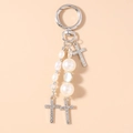 Dettaglio del portachiavi a croce d'argento con strass scintillanti e perle bianche - Stile Croce Perla Strass