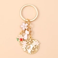 Detail of golden cat and cherry blossom keychain with enamel finish and sparkling rhinestones - Pink Cat Flower
