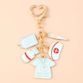 Dettaglio portachiavi a tema medico con moschettone a cuore e ciondoli da infermiera - Collezione Ciondoli Cappello Uniforme Infermiera Blu