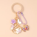 Dettaglio dei ciondoli a forma di coniglio, fiore e farfalla sul portachiavi - Viola Fiore Farfalla Coniglio