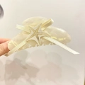 Macro detail of starfish acetate hair claw clip with elegant ribbon bow for women - Large / Pearl White