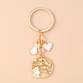 Detail van een gouden sleutelhanger met een wit konijn, kersenbloesems en roze hartje - Bloem Konijn Hart