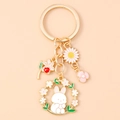 Close-up of enamel flower rabbit keychain with daisy and cherry blossom charms - Floral Rabbit