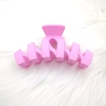 Minimalistische große matte rosa Haarklammer in N-Form auf weichem weißem Plüsch - Pfirsichrosa