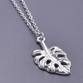 Détail macro du pendentif feuille de monstera en argent poli avec nervures évidées - Set de colliers / Acier