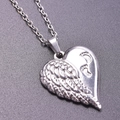Gros plan du pendentif cœur en acier inoxydable avec relief d'aile et empreintes - Collier / Argent