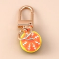 Macro view of detailed orange slice resin keychain with gold metallic D-ring buckle - Orange