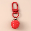 Close-up of realistic strawberry keychain with red lobster clasp and green leaf details - Strawberry