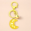 Detalle de llavero de luna amarilla en resina con estrellas y un pequeño cascabel - Amarillo