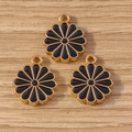 Macro detail of three flower-shaped black enamel charms with golden metal edges for DIY crafts - Black
