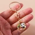 Detailaufnahme eines Panda- und Bambus-Emaille-Anhängers an einem goldenen Schlüsselring - Runder Panda