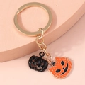 Detail of Halloween keychain with black pumpkin and orange cat-faced enamel charms on gold ring - Hollow Cat Face Pumpkin
