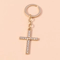 Makro-Detail vom goldenen Kreuz-Schlüsselanhänger mit Herz und Pavé-Kristall-Strasssteinen - Herz und Kreuz