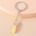 Macro shot of light yellow hexagonal crystal pillar keychain with silver metal edge - Goose Yellow