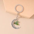 Detail of ethnic crescent moon keychain with hollow design and green stone charms - Dark Green Stone Moon