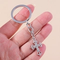 Close-up of silver christian cross keychain with sparkling rhinestones and hollow engraving - Silver Hollow Cross