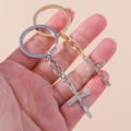 Dettaglio di portachiavi a croce cristiana in oro e argento con strass scintillanti - Croce Arrotondata Oro E Argento