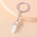 Macro detail of hexagonal white crystal bullet pendant keychain on round display - White