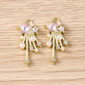 Detail of star-shaped pendants with pink heart crystal and pearls on wood background - Gold Pink