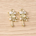 Macro detail of Y2K star pendants with rhinestones, pearls, and gold-plated metal tassels - Gold White