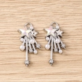 Detail of silver Y2K star pendants with faux pearls and rhinestones on wood texture - Silver Pink