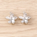 Close-up of flower shaped metal pendants with sparkling crystal inlay for DIY jewelry - Silver
