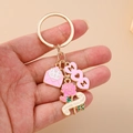 Close-up of golden MOM keychain with pink heart, envelope and rose charms held in hand - Pink Flower Envelope