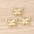 Détail de pendentifs papillons dorés avec perles blanches et strass pour bijoux DIY - Papillon doré