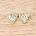 Macro shot of two gold heart-shaped pendants with light blue enamel and star details - Gold Blue