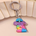 Dettaglio del portachiavi UFO in acrilico con alieno verde e arcobaleno su vassoio in ceramica - UFO Viola