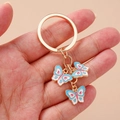 Portachiavi alla moda con farfalla in smalto colorato e tre ciondoli dorati - Farfalla Blu