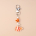 Detail view of clownfish keychain with starfish, pearl, and silver lobster clasp accessory - Orange Starfish Clownfish