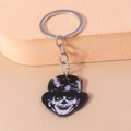 Macro shot of a Halloween skull keychain with top hat and silver metal ring and chain - Clown