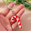 Detail of a red and white striped Christmas candy cane keychain with a silver ring - Red White Candy Cane