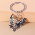 Détails macro de breloques chauve-souris en émail noir gothique et porte-clés argenté étoilé - Chauve-souris