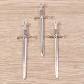 Primer plano de dijes de espada gótica plateada sobre madera para hacer joyería - Paquete de 10 / Plateado